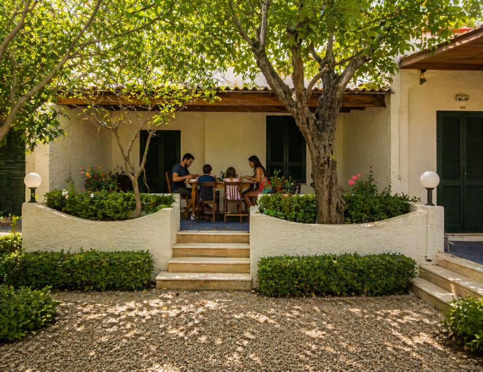 a family sitting at a table outside of a house at Cala Dei Saraceni in Peschici