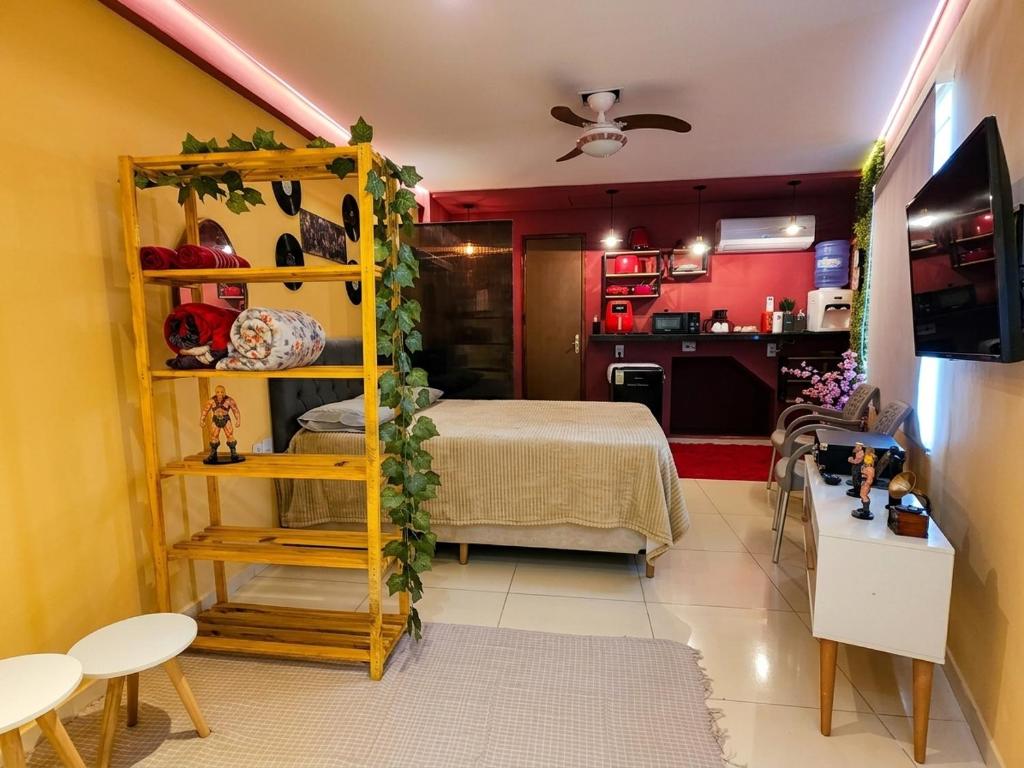 a small room with a bed and a kitchen at Retro Flat in Caruaru