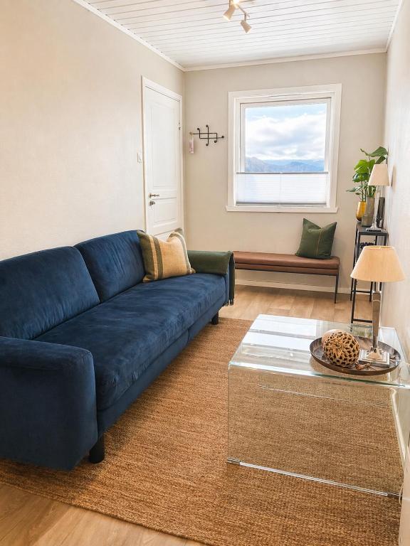 a living room with a blue couch and a table at Nordic Studio - Gravdal, Lofoten in Haug