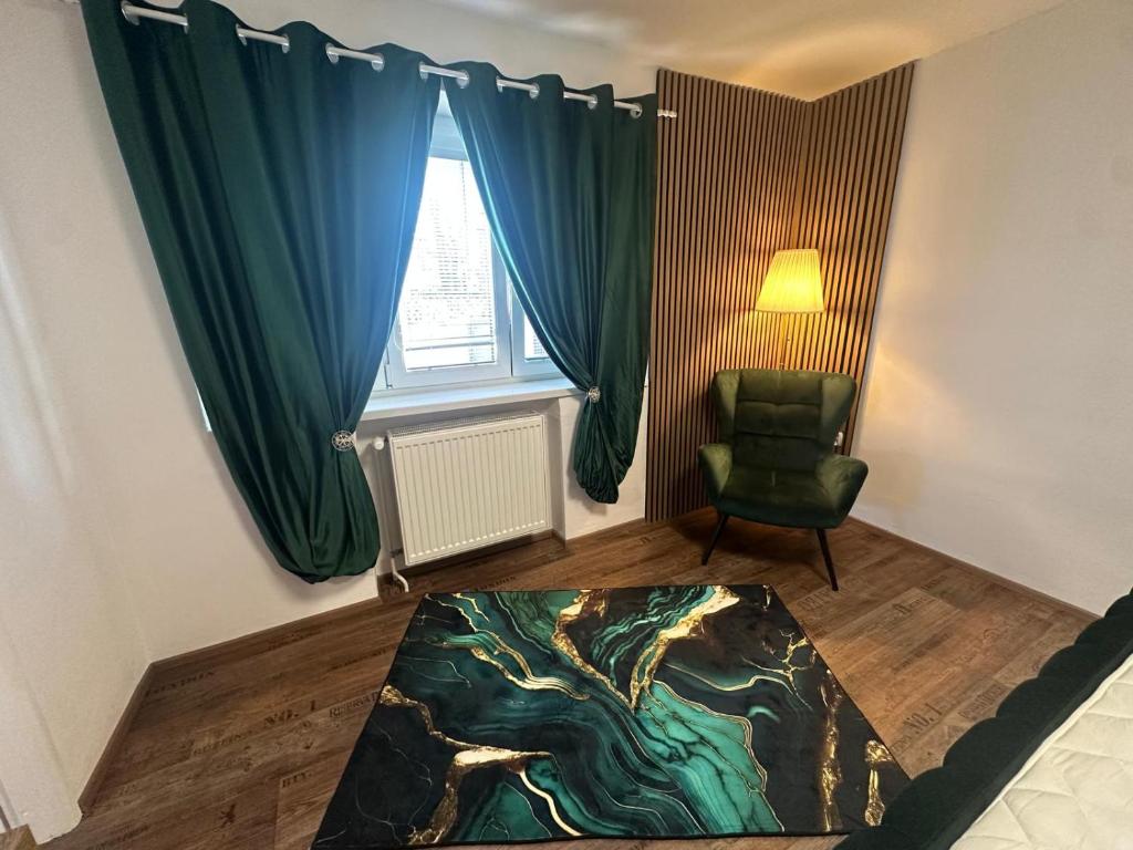 a living room with a green chair and a window at Hauspark Residence in Žatec