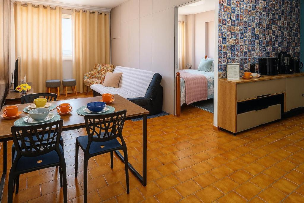 a living room with a couch and a table and chairs at Studio chamorso - Cama Queen - AC - Garagem in Rondonópolis