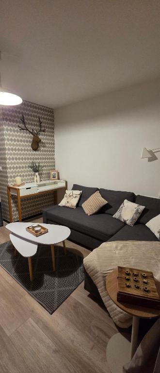 a living room with a couch and a table at Appartement T1 Superdévoluy 6 personnes in Le Dévoluy