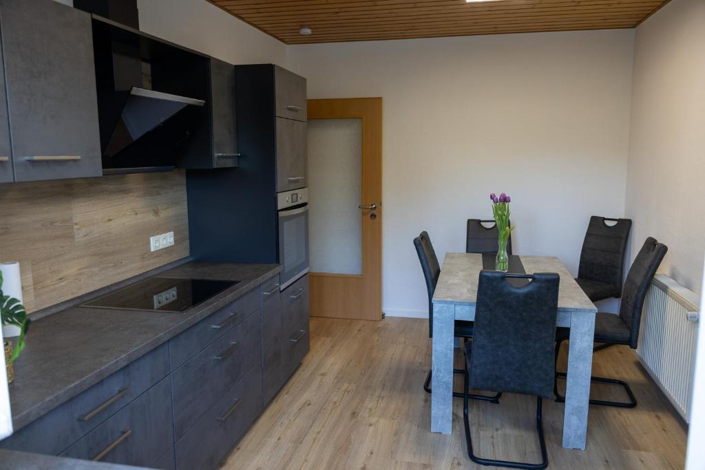 a kitchen with a dining room table with chairs at Auszeit im Sauerland in Meschede