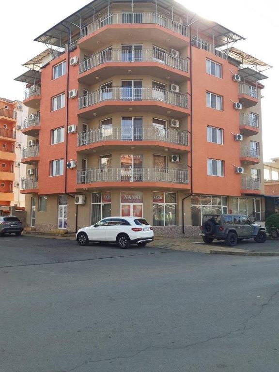 a white car parked in front of a large building at Къща Нанси in Sunny Beach