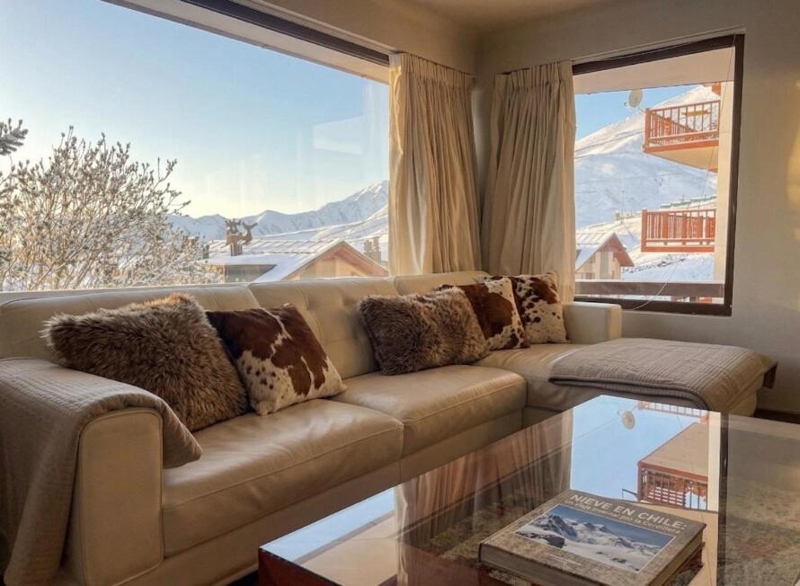 a living room with a couch and a large window at Increible Chalet en La Parva in Santiago