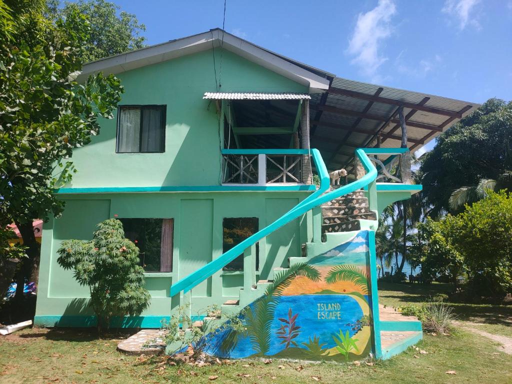 a house with a slide in front of it at Guesthouse Island Escape in Corn Islands