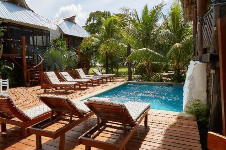 a group of chairs sitting around a swimming pool at Sohla Hotel Popoyo in Playa Santana
