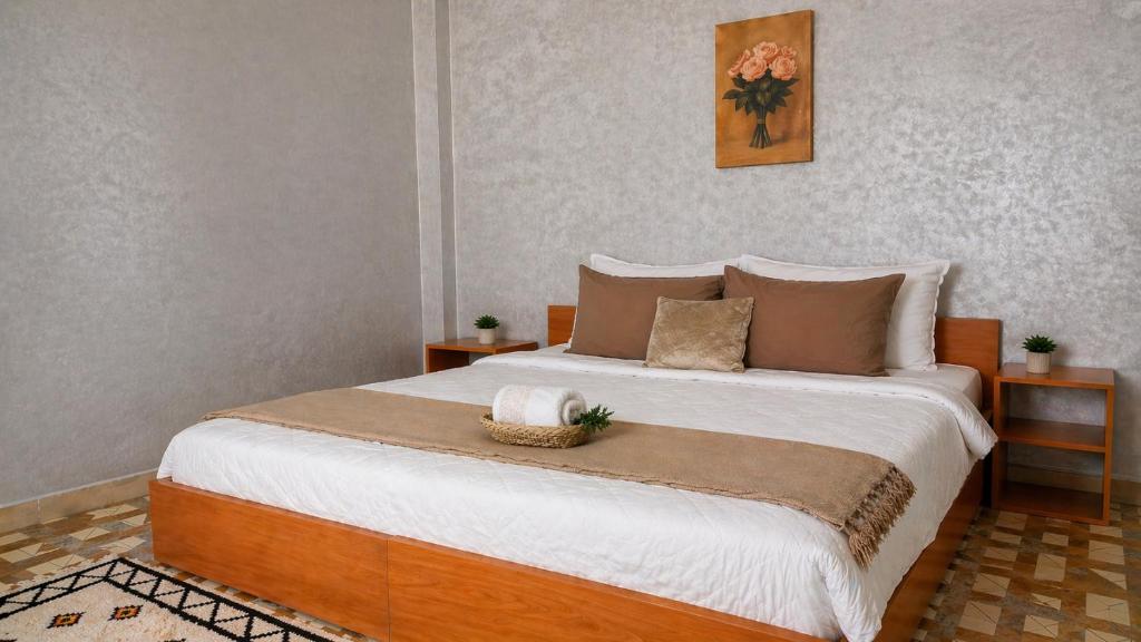 a bedroom with a large bed with two tables at Cozy Guesthouse in Aourir near Tamraght in Aourir