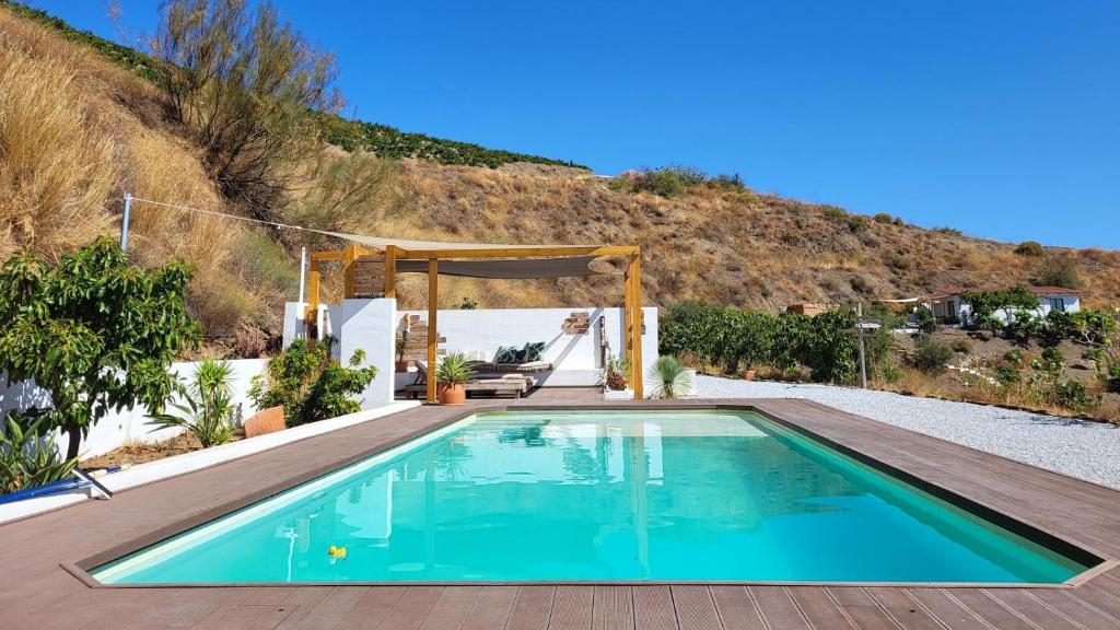 a swimming pool in the middle of a yard with a wooden deck at Casa Gaïa in Borge