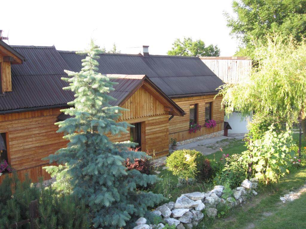 a log cabin with a pine tree in the yard at Chata za Wsią u Kowalików in Skała