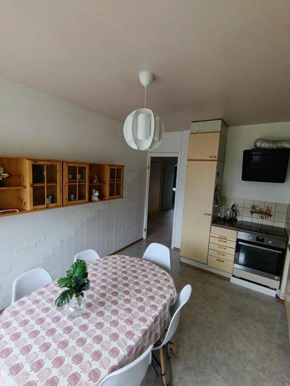 a dining room with a table and a kitchen at Kolmio Väinöläntie 6 in Lieksa