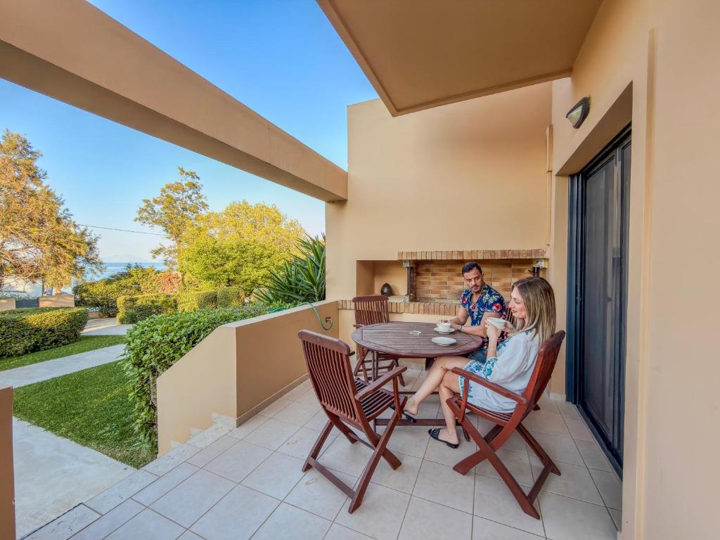 a man and a woman sitting at a table on a patio at Seliandros Aura Villa in Dhiminión
