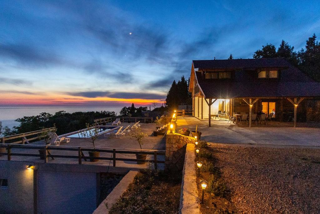 a house with lights on the side of it at dusk at Olive Panorama Villa in Dobra Voda