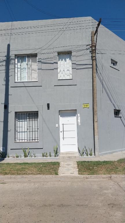 a gray house with a white door on a street at La casita de Susi in San Pedro