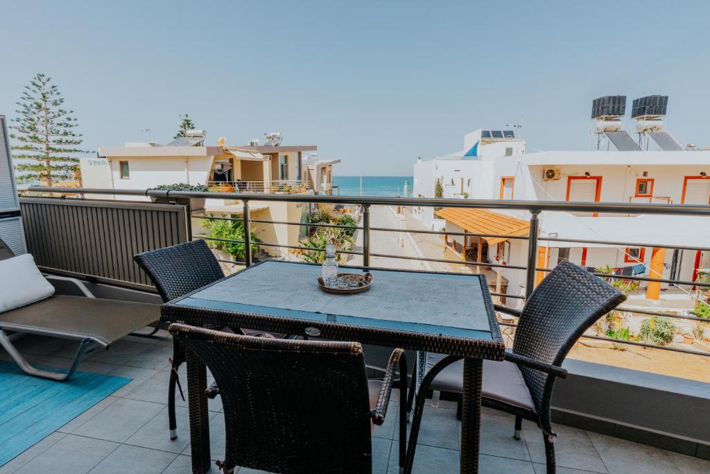 a patio with a table and chairs on a balcony at Seaside suite in Crete in Kokkini Khanion