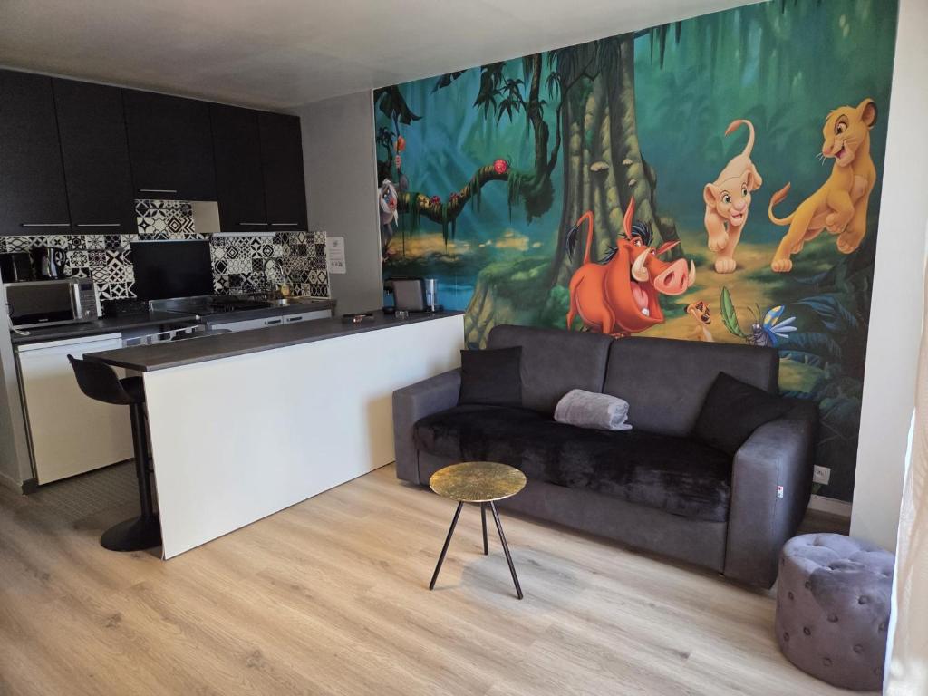 a living room with a couch and a kitchen at Studio à 2 pas de Disneyland in Esbly