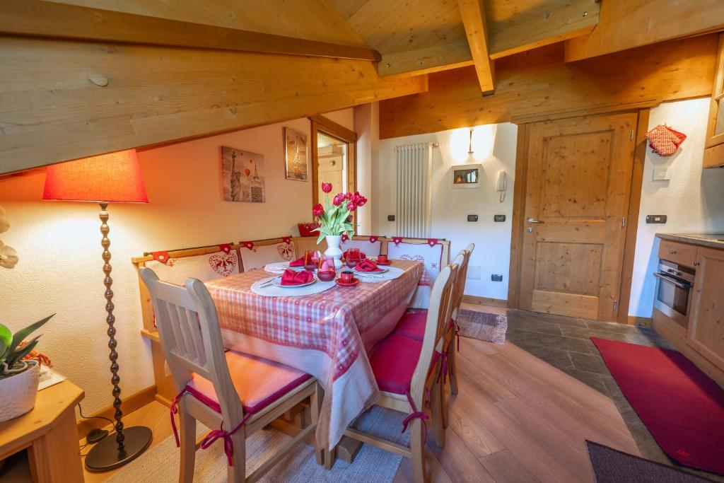 a dining room with a table and chairs and a lamp at Chalet Adda - Appartamento mansarda con garage privato in Bormio