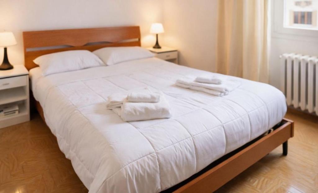 a bedroom with a large white bed with towels on it at A&D BnB in Porretta Terme