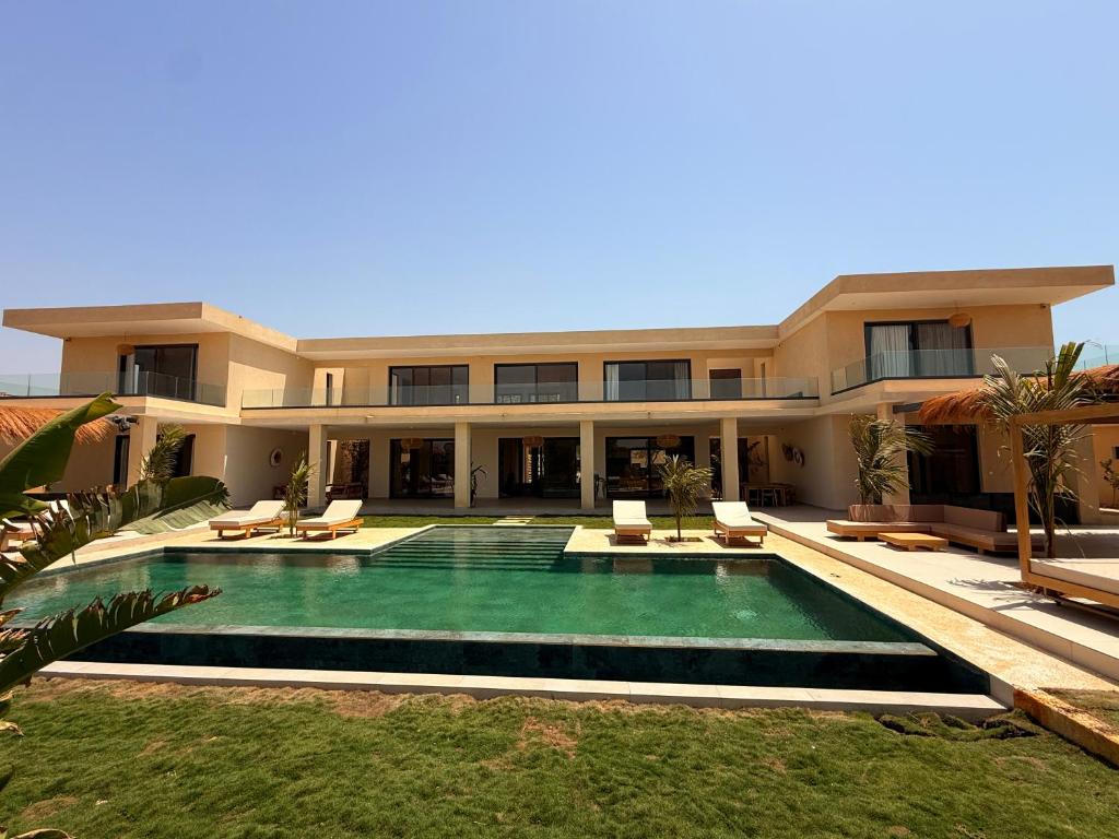 a large house with a swimming pool in front of it at Villa Tarrafal in Somone