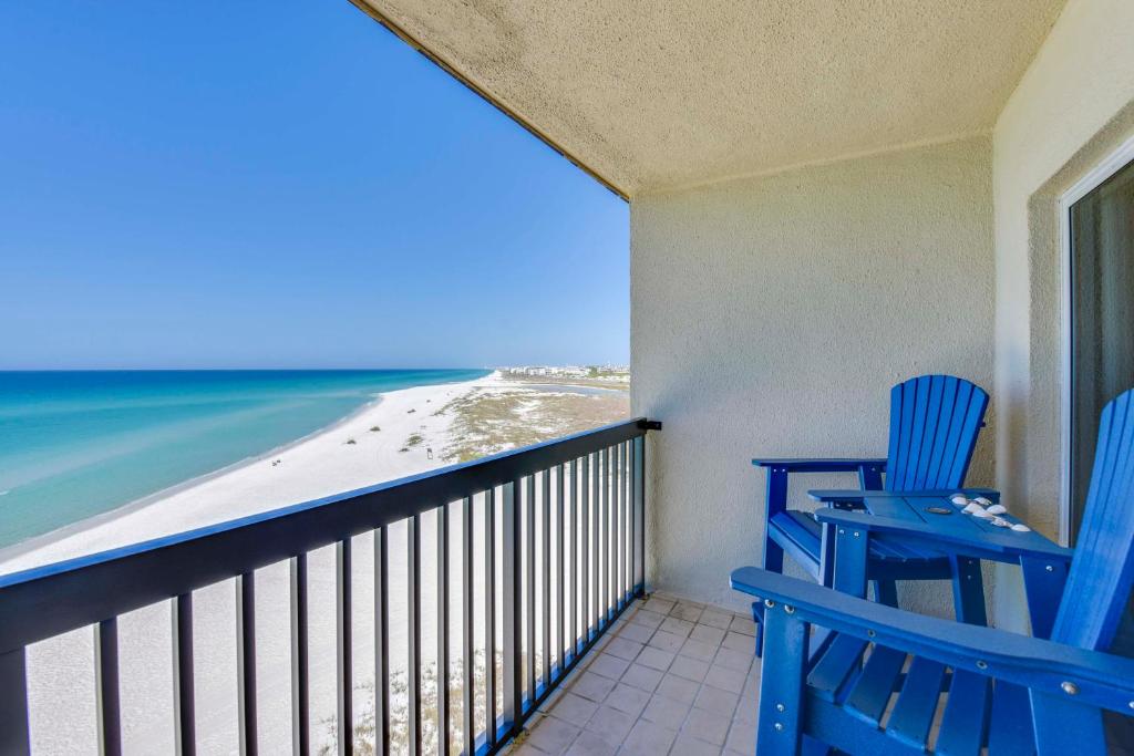 two blue chairs on a balcony overlooking the beach at ‘Emerald Dreams’ Beach & Lakefront West PCB Condo in Panama City Beach