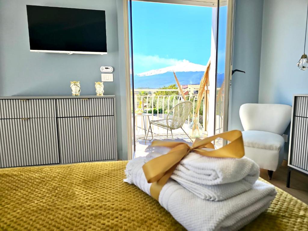 a room with a pile of towels and a television at SuiteLina in Giardini Naxos