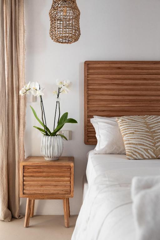 a bedroom with a bed and a vase with flowers on a night stand at EOS Gaeta in Gaeta
