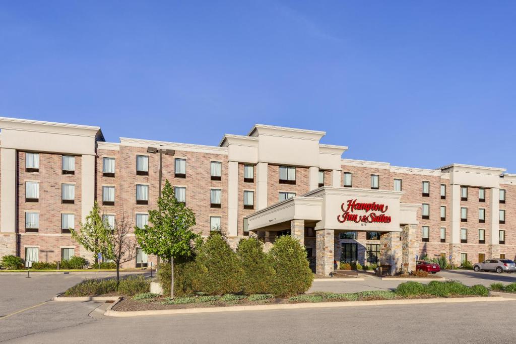 a large brick building with a sign on it at Hampton Inn & Suites West Bend in West Bend