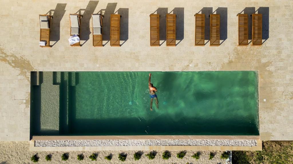 a man standing in the water in a swimming pool at ORTO NOTO - Agri Resort in Noto