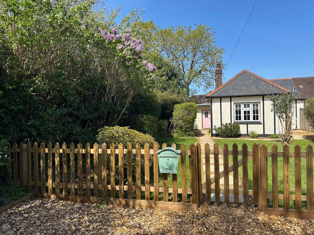 a fence with a mailbox in front of a house at Hollylea Cottage - New Forest in Godshill