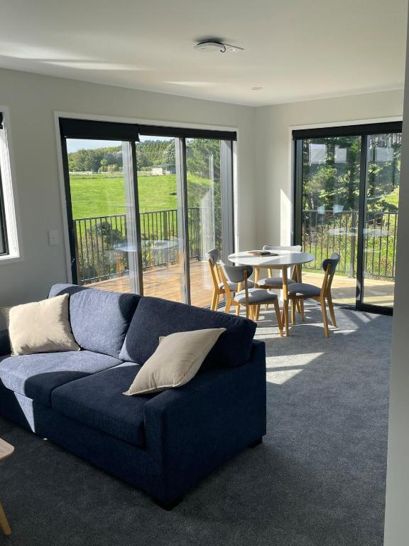 a living room with a blue couch and a table at Blacksmith's Rest in New Plymouth