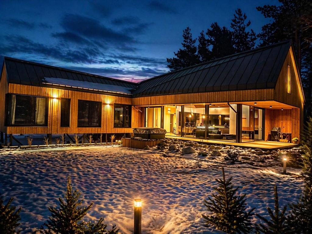 a house with a courtyard in the snow at night at Chalet Beyond in Veľká Lomnica