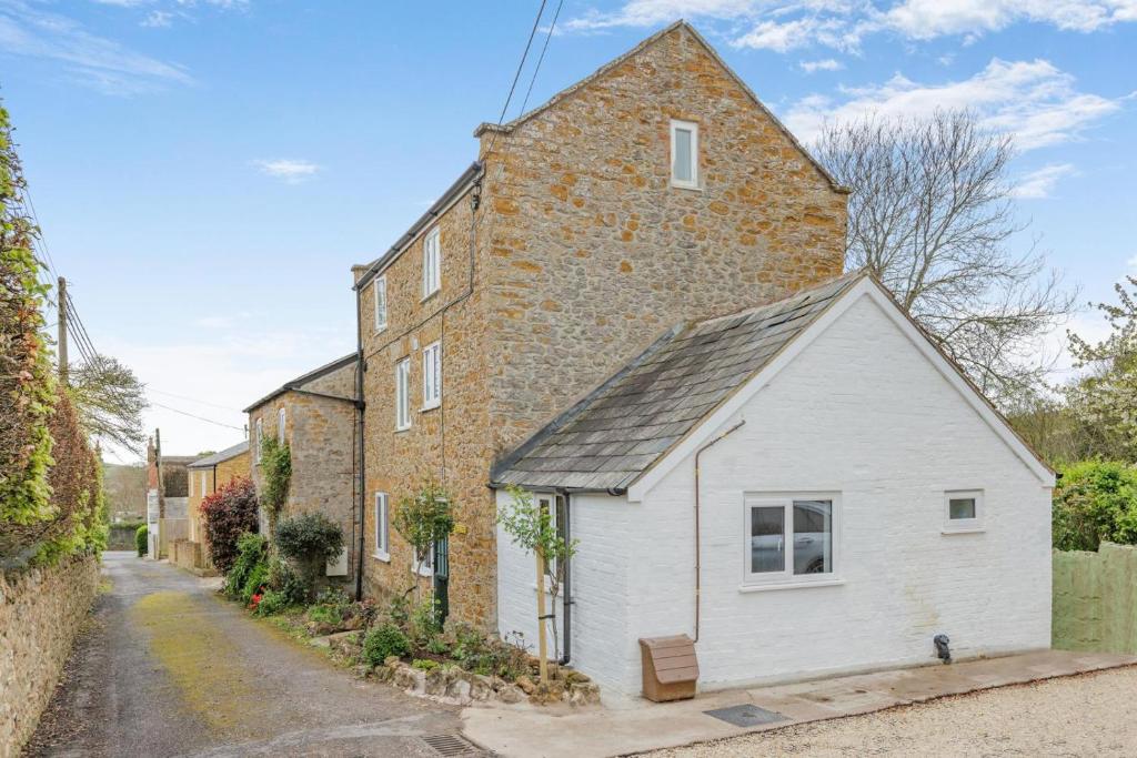 an old brick building with a white shed at 2 Bed in Chideock oc-c36616 in Chideock