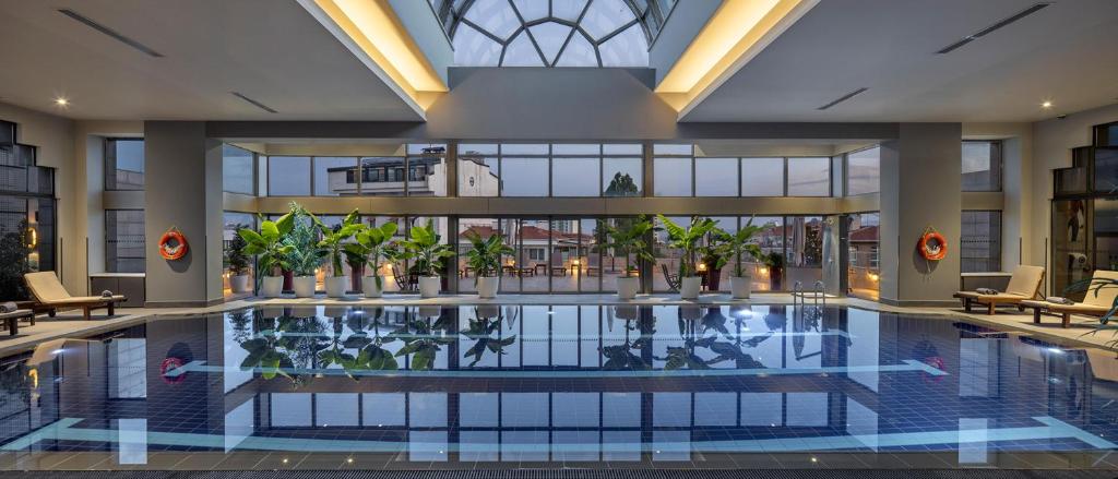a large swimming pool in a building with a building at Ankara HiltonSA in Ankara