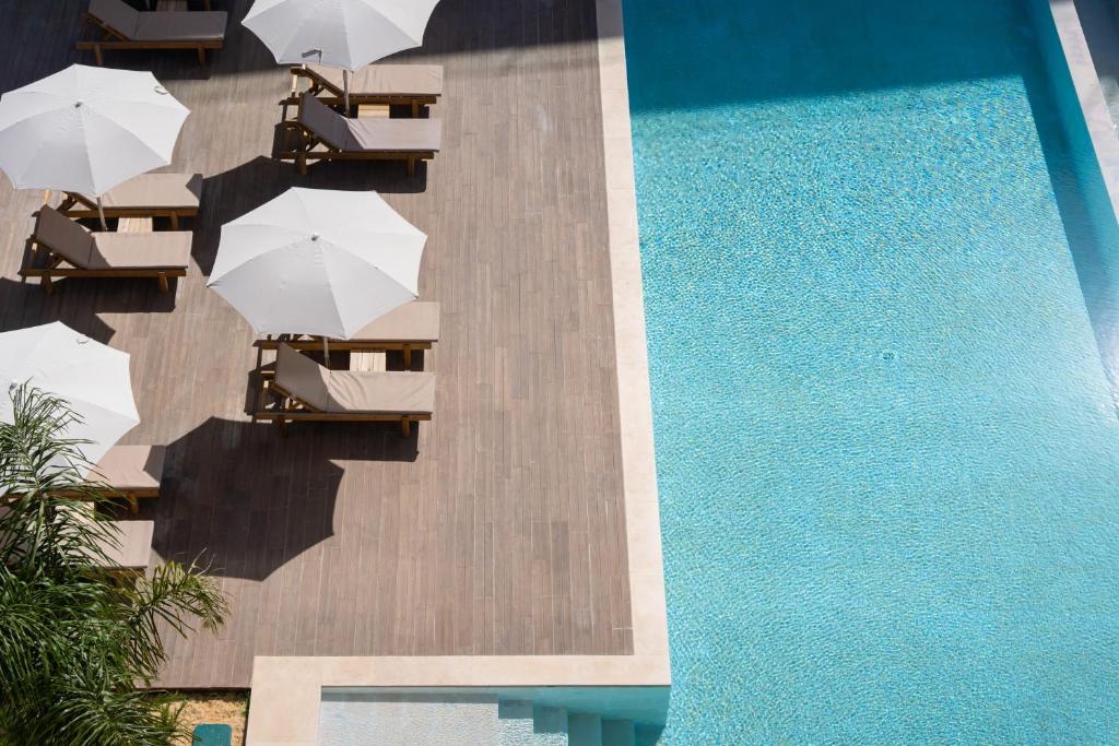 an overhead view of a swimming pool with chairs and umbrellas at Riva Waterfront in Olhão
