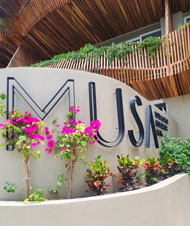a sign for a building with flowers on it at Musa Hotel Boutique in Bucerías