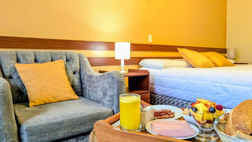 a hotel room with a couch and a table with a tray of food at Hotel San Lázaro Arequipa - Cochera - Hotel en Arequipa in Arequipa