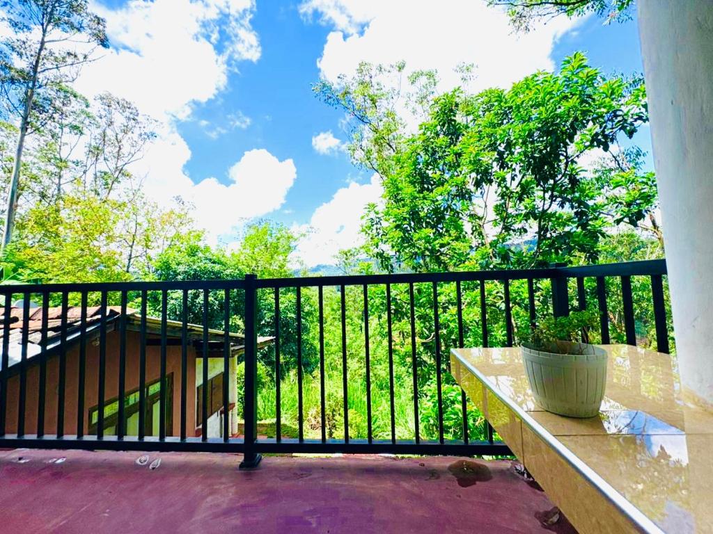 a balcony with a black fence and a bench at Oli Guest House Diyatalawa in Diyatalawa