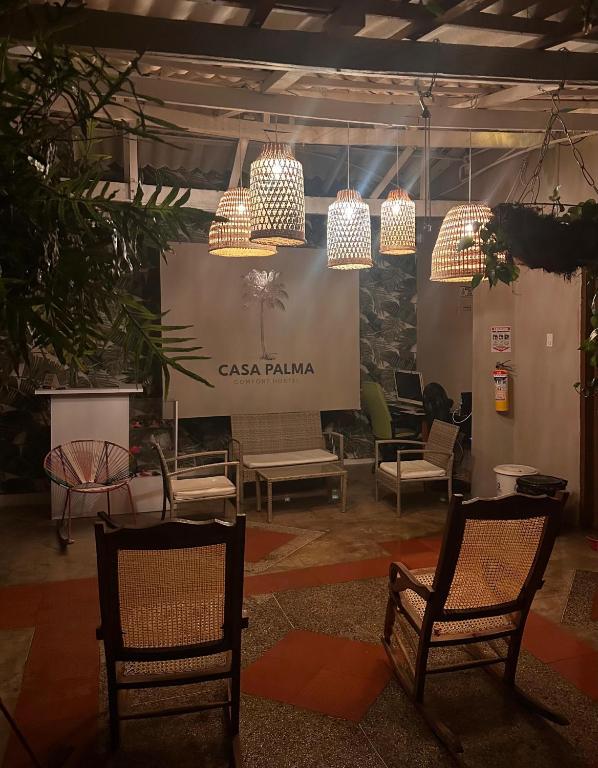two chairs and chandeliers in a room with a stage at HOSTAL CASA PALMA in Ríohacha