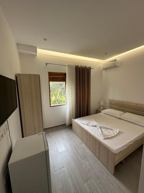 a bedroom with a large bed and a window at Visi Villa Berat in Berat