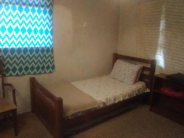 a small bedroom with a bed and a window at Comfy Room 2 in Overland Park