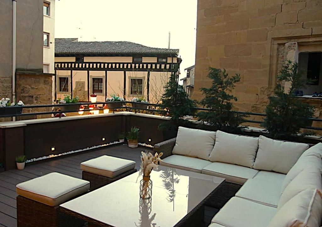 eine Terrasse mit Sofa und Tisch auf einem Balkon in der Unterkunft Edificio Privado con Terraza in Haro