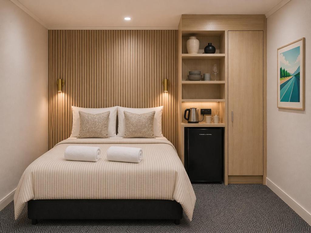 a bedroom with a large bed with two pillows at Tauranga Backpackers - Private Guest Rooms by the Water! in Tauranga