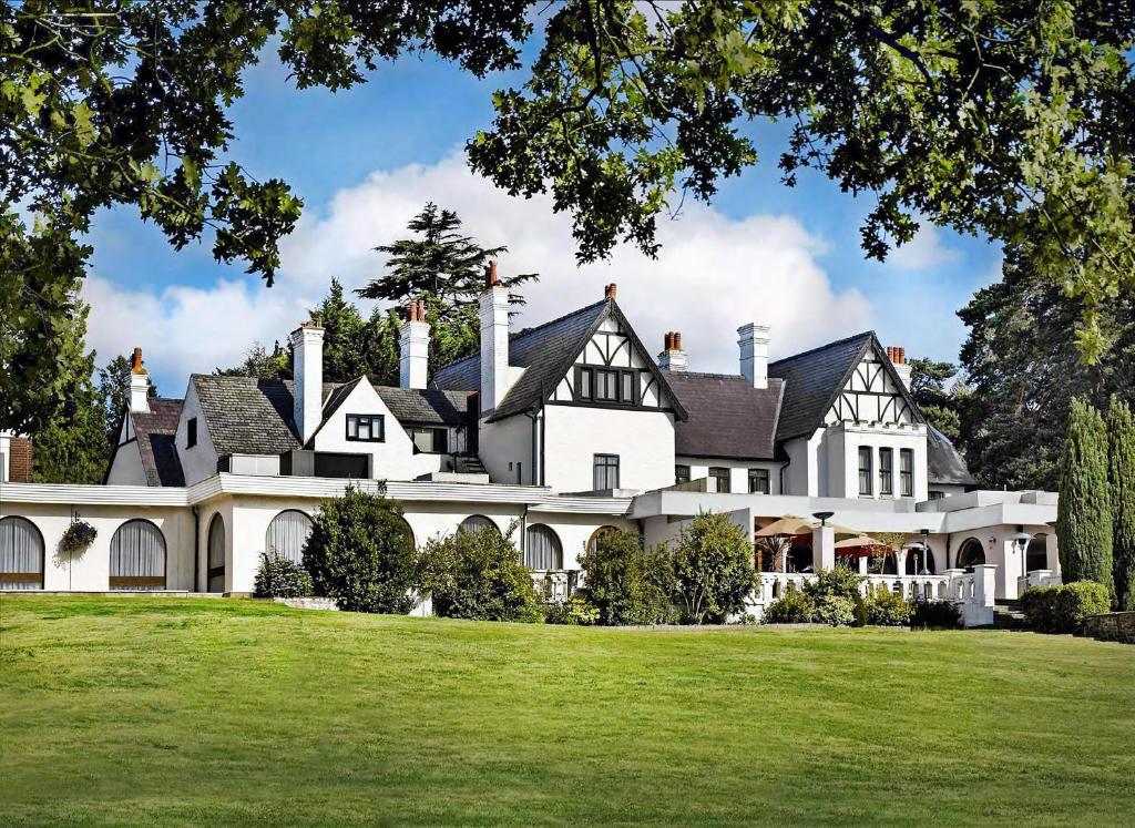 an exterior view of a large white house at Hilton Cobham in Cobham