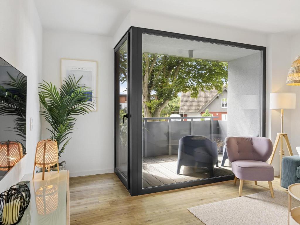a mirror in a living room with a chair and a table at Schulzenhufe an der Ostsee in Beckerwitz