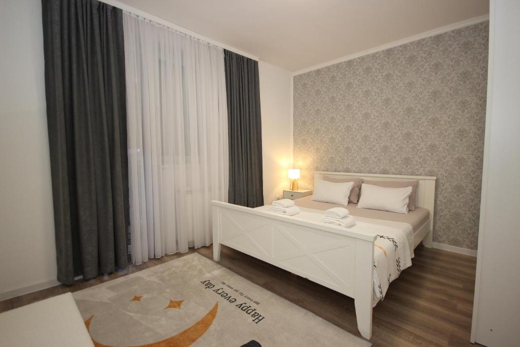 a bedroom with a white bed and a window at Stan na dan Moonlight Panonija in Inđija