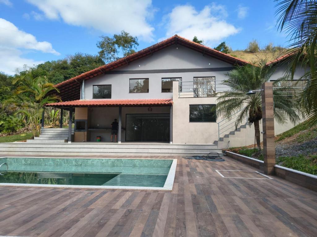 a house with a swimming pool in front of it at Sítio Belo Vale in Cataguases