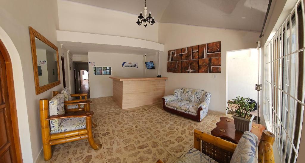 a living room with a couch and a chair at Caribbean Airport Hotel in Cartagena de Indias