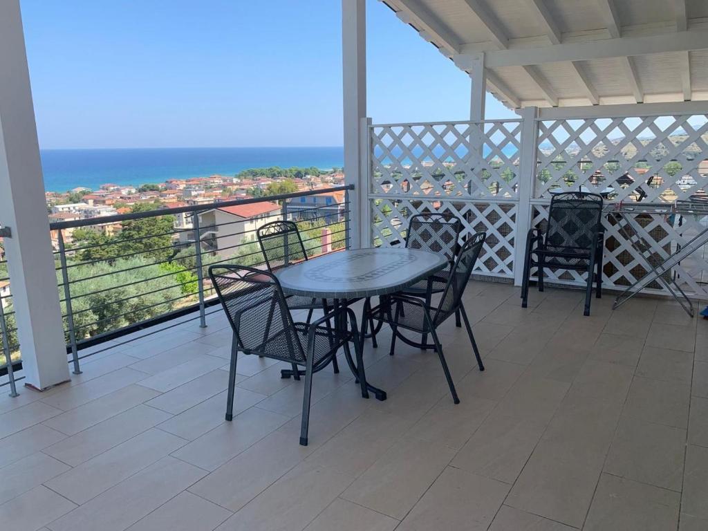 a table and chairs on a balcony with a view of the ocean at VILLA ARCANGELO Lo in Mandatoriccio Marina