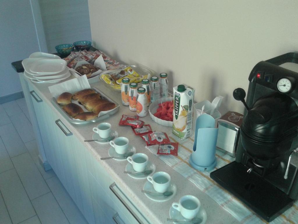 a kitchen counter with a table with food and cups at B&B L'Uliveto in Marina di Schiavonea