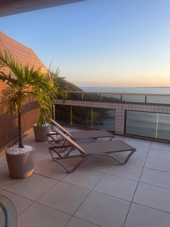 a patio with a chair and a view of the ocean at Paraíso à vista Cobertura Linear Canto Nobre in Guarapari